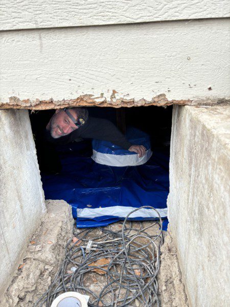 Finishing crawlspace encapsulation — vapor barrier sealed at foundation